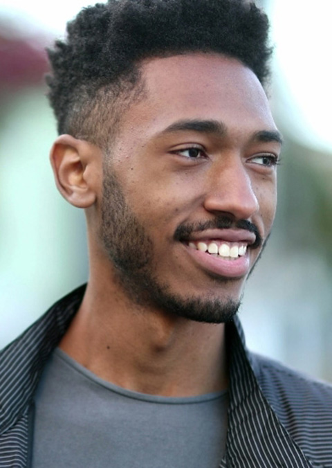 Mixed-race-young-man-walking-outside-in-sidewalk